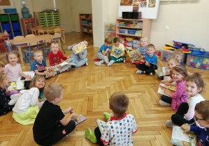 Dzieci siedzą na podłodze z książkami